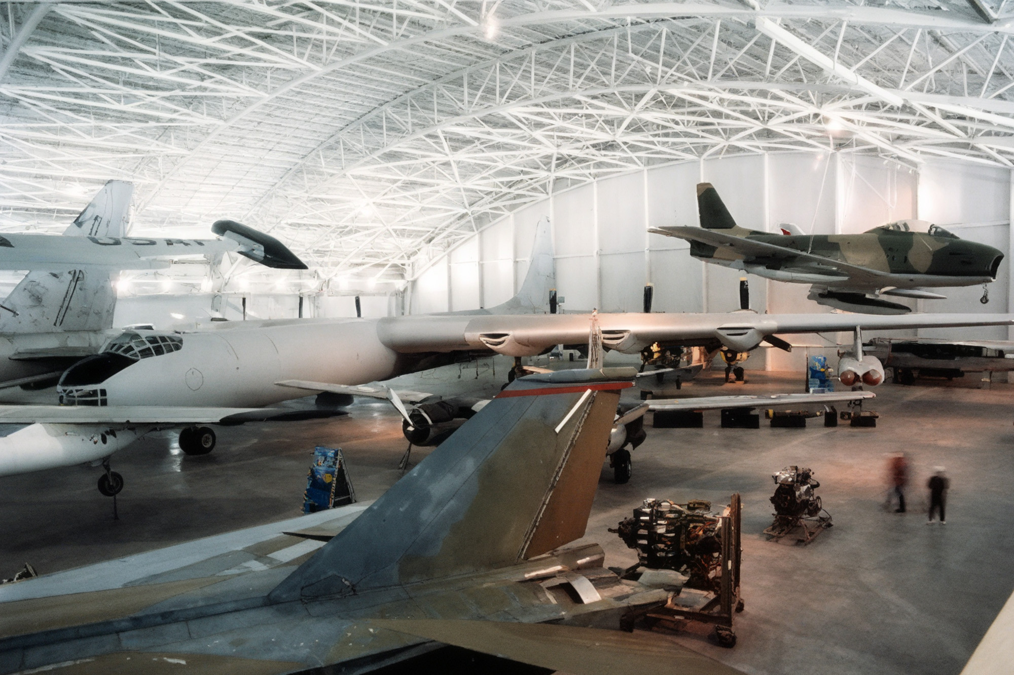Aviation museum hangar with white steel truss roof and multiple aircraft displayed